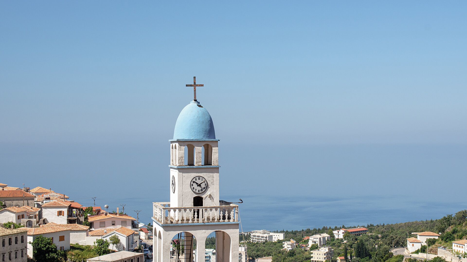 Charming clock tower with a blue dome in a scenic small town, a hidden gem in the Albanian Riviera.